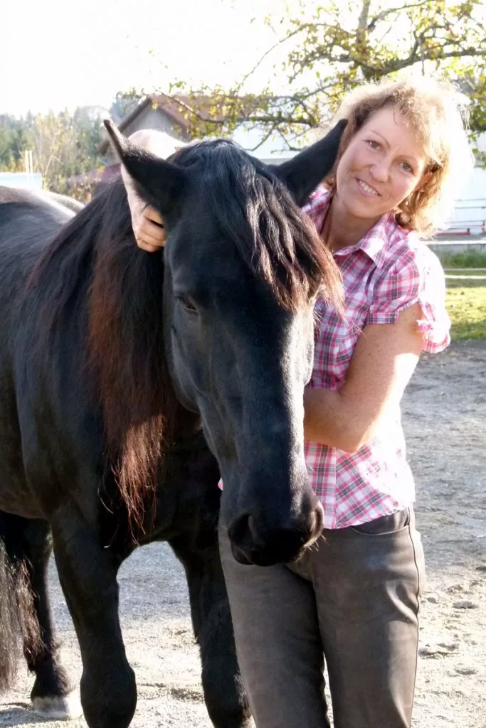 Sabine Junginger mit ihrem schwarzen Pferd in vertrauter Begegnung